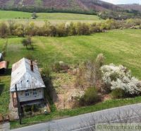 A family house in Zubné surrounded by nature and fields, with a wooden roof.