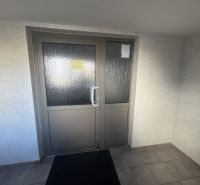 Entrance door with glazing in a 3-room apartment with ceramic tiles.