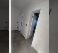 Interior of a holiday apartment with white walls and a floor with a wood decor.