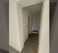 A corridor with tiles and white walls in a holiday apartment.