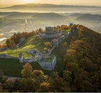 A castle on a hill surrounded by autumn-colored forests in the area of Veľký Šariš.