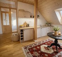 Attic kitchen in a family house with a wooden decor floor and carpet.