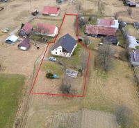 Aerial view of a family house in Oravská Lesná surrounded by land and neighboring buildings.