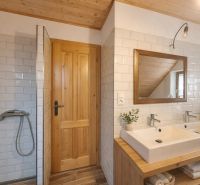Bathroom in a family house with white tiles and a mirror.