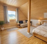Bright bedroom in a family house with wood-decor flooring and a well-lit interior.