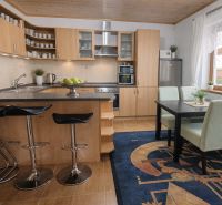 A kitchen in a family house with wooden decor and a dining nook.
