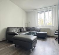 A comfortable view of the living room with a leather sofa set and a wooden decor floor.