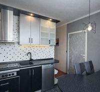 A kitchen in a 3-room apartment with tiles contrasting black and white elements.