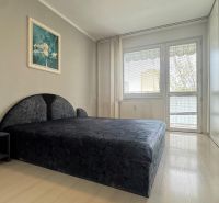 A bedroom with a large bed and a built-in wardrobe in a 3-room apartment.