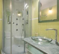 A bathroom in a 3-room apartment with a shower and a glass sink.