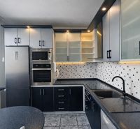 A kitchen in a 3-room apartment with ceramic tiles and spot lighting.