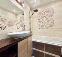 Bathroom in a 3-room apartment with floral tiles, a sink, and a bathtub.