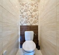 A toilet with a decorative wall in a 3-room apartment with a floral design.