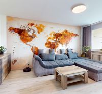 Living room in a 3-room apartment with a map on the wall and a floor with a wooden decor.