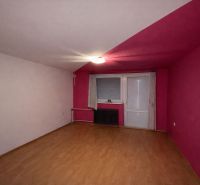A room with pink walls and a wooden decor floor in a family house.