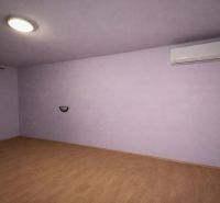 A room with air conditioning and a wooden decor floor in a family house.