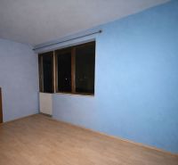A room in a family house with blue walls and a wooden decor floor.