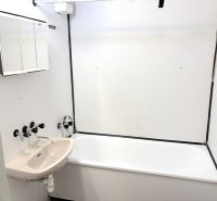 Bathroom with a bathtub and sink in a studio apartment.