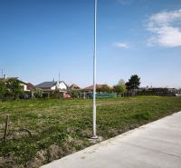 Residential plots in Čierny Brod, green area next to the concrete sidewalk.