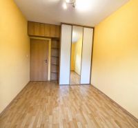 A room in a 3-room apartment with a wooden decor floor and a built-in wardrobe.