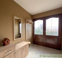 Entrance hall with wooden furniture and a mirror in a family house.