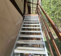 Exterior stairs leading to a family house in Cinobana with a green background.