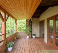 A wooden terrace in a family house in Cinobana with a view of the forest environment.