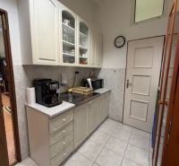 Offices with a coffee machine and white cabinets, tiles, next to the kitchen.