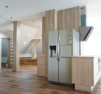 A kitchen with built-in appliances and a wooden decor floor in a 4-room apartment.