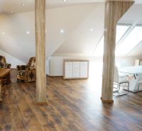 Attic space of a 4-room apartment with furniture and flooring featuring a wooden decor.