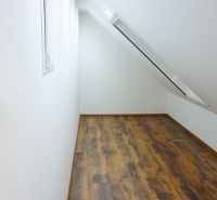 Attic room with a skylight and a wooden decor floor in a 4-room apartment.