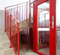 A hallway with a staircase and a red elevator in a 4-room apartment.