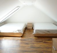 Attic room in a 4-room apartment with beds and a floor with a wooden decor.