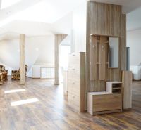 Attic interior of a 4-room apartment with a wooden decor floor and comfortable seating.