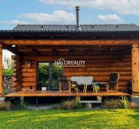 A wooden veranda of a cottage in Piešťany with comfortable chairs and greenery.
