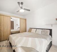 Bedroom with a double bed, wardrobe, and fan in a two-room apartment.