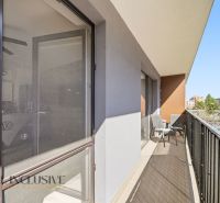 Balcony of a 2-room apartment on Zuzany Chalupovej with furniture and a sunshade, in the background Petržalka.