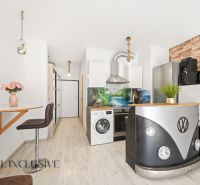 A kitchen with an original VW table and a floor with a wooden decor in a 2-room apartment.