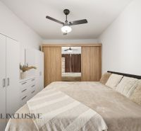 A bedroom with a large bed and a wardrobe in a 2-room apartment.