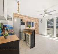 A kitchen with a bar counter and a wooden decor floor in a 2-room apartment.