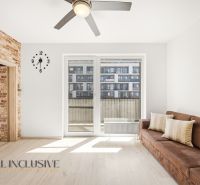 A bright living space in a 2-room apartment with a sofa and a balcony.