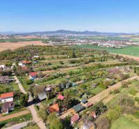 Country cottages around Nitra, surrounded by fields and greenery with views of the hills.