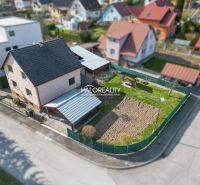 A family house in Považská Bystrica with a landscaped garden and adjacent buildings.