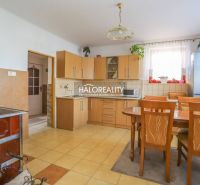 Family house kitchen, light wooden cabinets, dining table, stove, refrigerator.