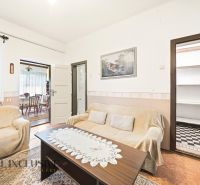 Living room in a family house with sofas, a table, and a picture on the wall.