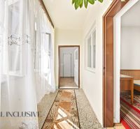 A hallway in a family house with a carpet runner and a view into the bedroom.