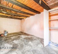 A basement in a family house with a wooden ceiling and a shelf, suitable for storage.