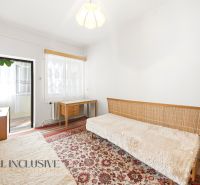 Interior of a family house with a carpet, sofa, table, and lamp.