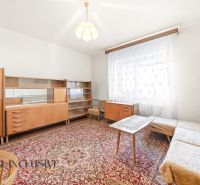 Living room in a family house with a carpet and wooden furniture.