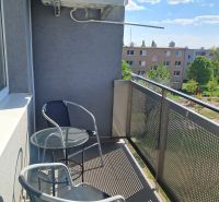 The balcony of a 2-room apartment on Považská in Senec with two chairs and a table.